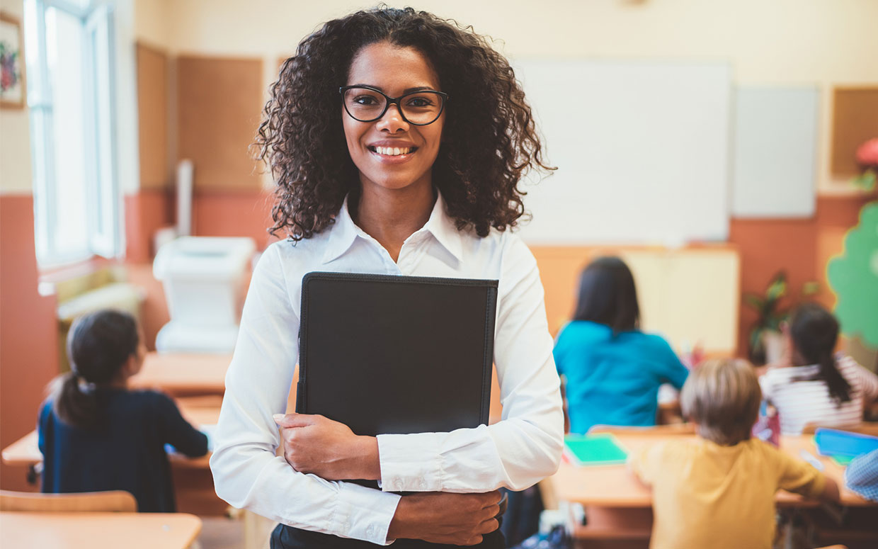 Female, African American, young adult holding folder and smiling.